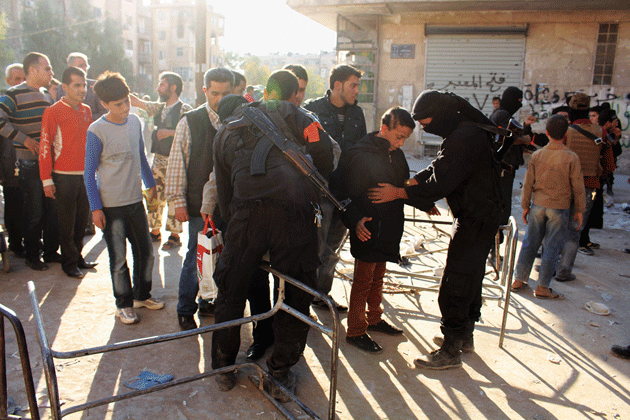 Fighters with Jabhat al-Nusra search residents at a checkpoint in Aleppo, Syria, October 2013 © Molhem Barakat/Reuters