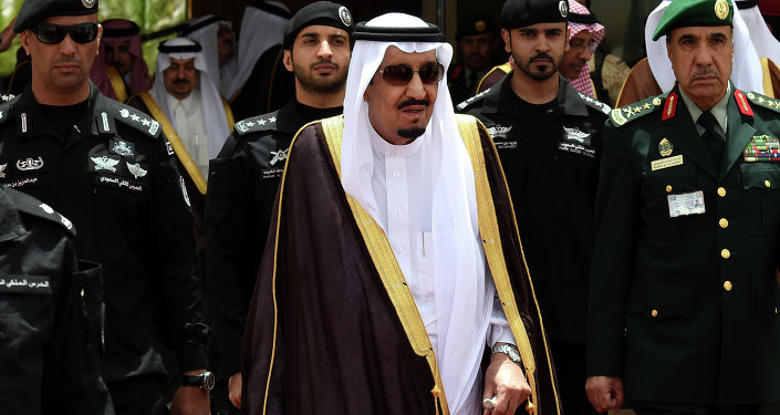 Saudi King Salman bin Abdulaziz (C) walks surrounded by security officers