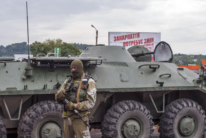 An interior ministry serviceman stands near an armoured personnel carrier (APC) at the scene of a shootout near Mukacheve, Ukraine, July 13, 2015. (Reuters)