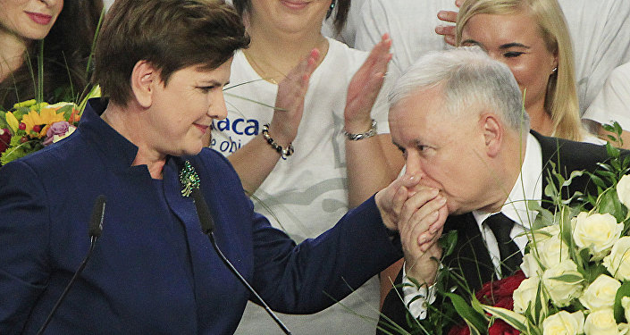 Conservative Law and Justice leader Jaroslaw Kaczynski kisses hand Justice candidate for the Prime Minister Beata Szydlo, left, at the party's headquarters in Warsaw, Poland, on Sunday, Oct.25, 2015