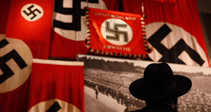 A man looks at exhibit showing the Nazi flags.