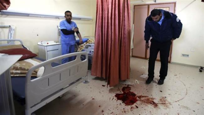 A medic looks at blood stain of a Palestinian man who was killed by Israeli undercover forces during a raid at Al-Ahly hospital in the West Bank city of al-Khalil (Hebron) on November 12, 2015. (Reuters)