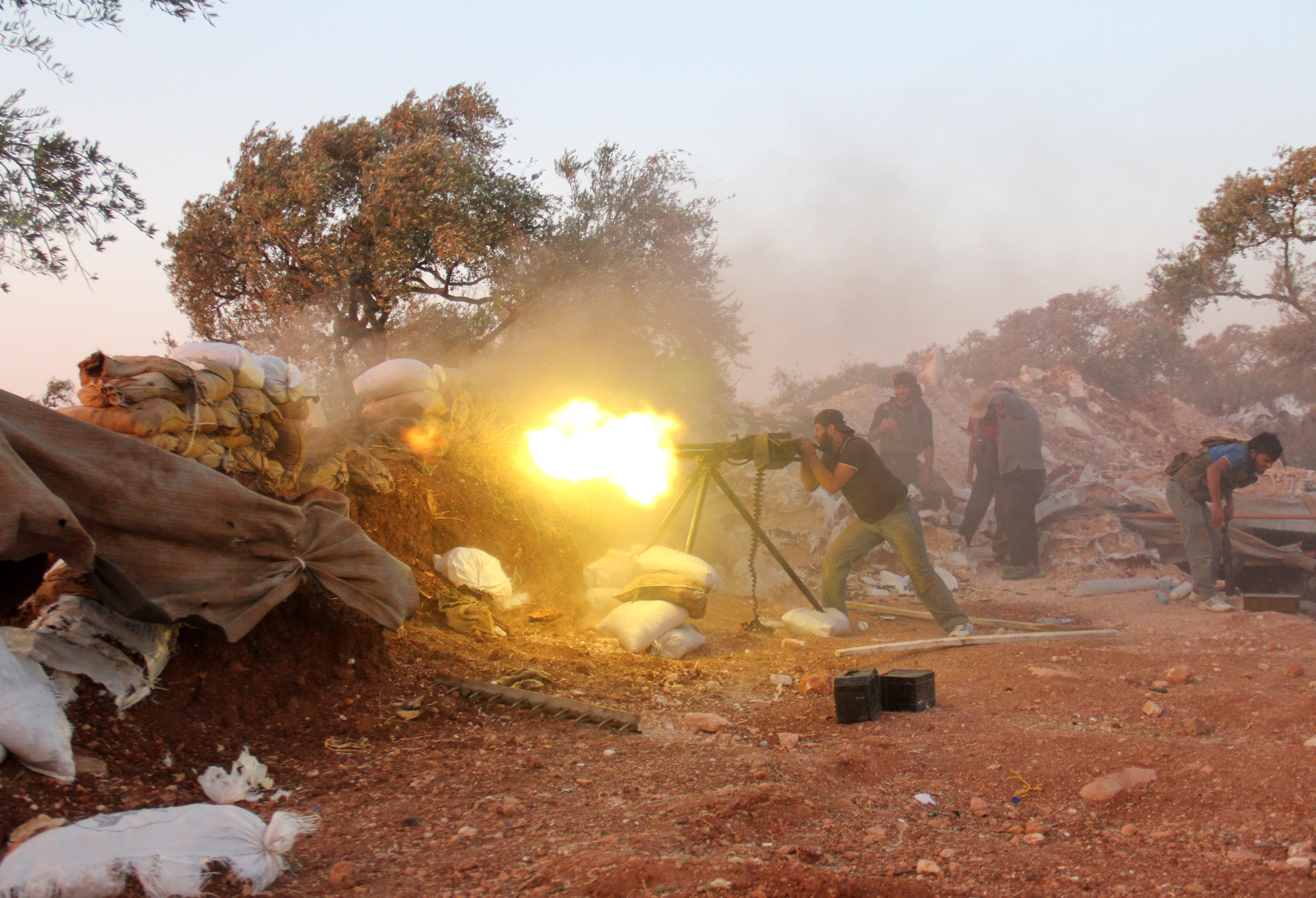 A rebel fighter fires a heavy machine gun during clashes with government forces and pro-regime shabiha militiamen in the outskirts of Syria's northwestern Idlib province on September 18, 2015