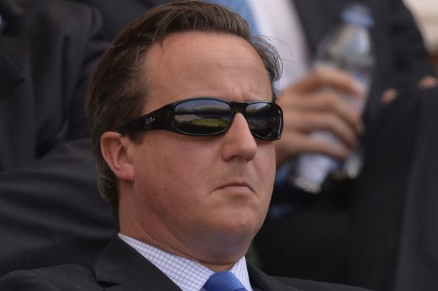 British Prime Minister David Cameron wears dark glasses as he sits in the royal box watching the men's singles final between Serbia's Novak Djokovic and Britain's Andy Murray