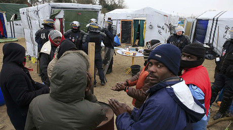 French CRS riot police secure the area near makeshift shelters during the partial dismantelment of the camp for migrants called the 