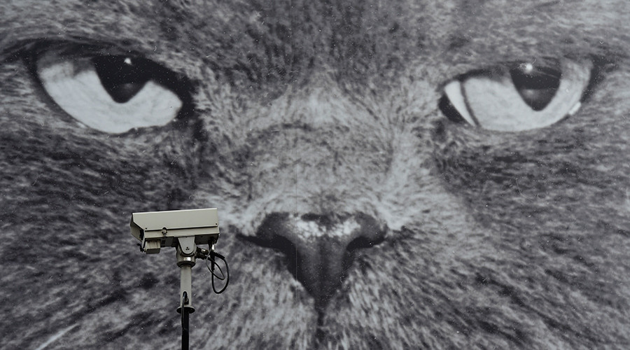 A CCTV camera is seen in front of a large poster opposite a London Underground Station in central London © Toby Melville