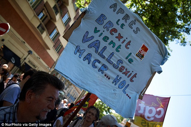 A demonstrator holds a placard reading 'after the Brexit comes the Vallsxit' during a protest on labour reforms