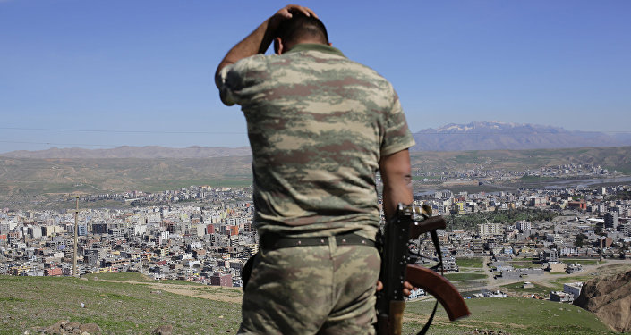 A Turkish soldier gestures while standing on the hill overlooking damaged buildings following heavy fighting between government troops and Kurdish fighters in the Kurdish town of Cizre in southeastern Turkey, which lies near the border with Syria and Iraq, on March 2, 2016