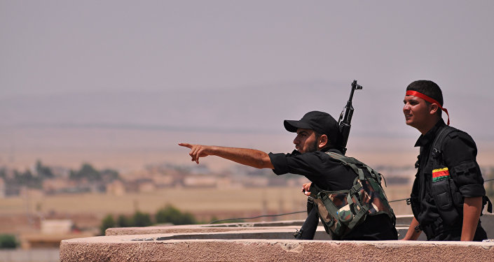 Fighters from the Kurdish People Protection Unit (YPG) monitor the horizon in the northeastern Syrian city of Hasakeh