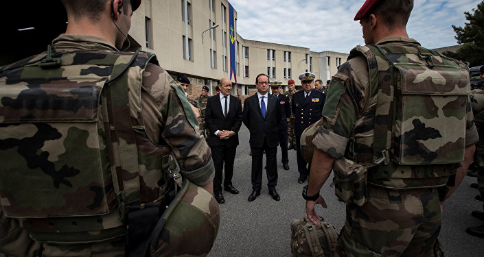 French President Francois Hollande (R) and Defence Minister Jean-Yves Le Drian review troops at the Army base and command centre for France's 'Vigipirate' plan, dubbed 'Operation Sentinelle', at the fort of Vincennes, on the outskirts of Paris, France, July 25, 2016