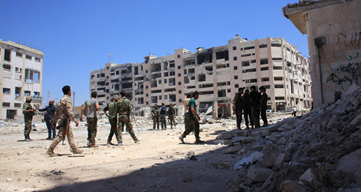 Syrian army soldiers patrol the area around the entrance of Bani Zeid after taking control of the previously rebel-held district of Leramun, on the northwest outskirts of Aleppo, on July 28, 2016