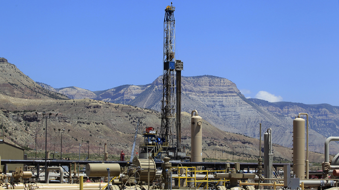 A natural gas drilling rig operates as natural gas piping rises from underground outside  Rifle, Colorado (Reuters / George Frey)