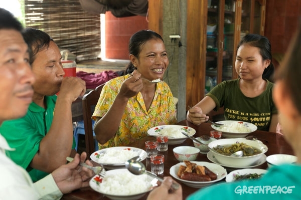Ecological farmer Sovanry Nhem and her family enjoy an ecological meal at home in Cambodia. © Peter Caton / Greenpeace