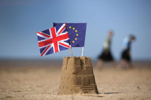 SOUTHPORT, UNITED KINGDOM - MAY 09: In this photo illustration the flag of the European Union and the Union flag sit on top of a sand castle on a beach on May 09, 2016 in Southport, United Kingdom. The United Kingdom will hold a referendum on June 23, 2016 to decide whether or not to remain a member of the European Union (EU), an economic and political partnership involving 28 European countries which allows members to trade together in a single market and free movement across it's borders for cirtizens. (Photo by illustration by Christopher Furlong/Getty Images)
