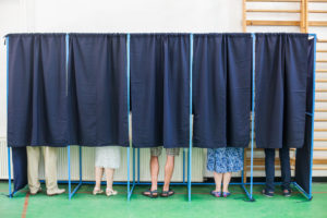 58315392 - color image of some people voting in some polling booths at a voting station.