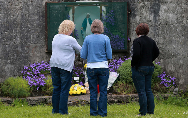 Women pay their respects at the grotto by the site of where 796 children from the Bon Secour Mother and Child home are believed to be buried. 