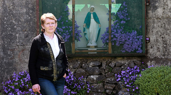 Historan Catherine Corless standing before the grotto in Tuam, Galway.