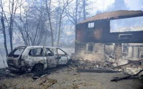 A home and vehicle are damaged from the wildfires around Gatlinburg, Tenn., on Tuesday, Nov. 29, 2016. Rain had begun to fall in some areas, but experts predicted it would not be enough to end the relentless drought that has spread across several Southern states and provided fuel for fires now burning for weeks in states including Tennessee, Georgia and North Carolina. (Michael Patrick/Knoxville News Sentinel via AP)