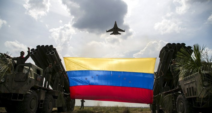 A Russian-made Sukhoi Su-30MKV fighter jet of the Venezuelan Air Force flies over a Venezuelan flag tied to missile launchers, during the Escudo Soberano 2015 (Sovereign Shield 2015) military exercise in San Carlos del Meta in the state of Apure