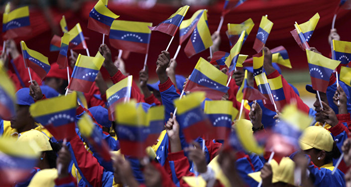 People wave Venezuelan flags during a parade marking 200 years of Venezuela's independence in Caracas, Venezuela, Tuesday July 5, 2011.
