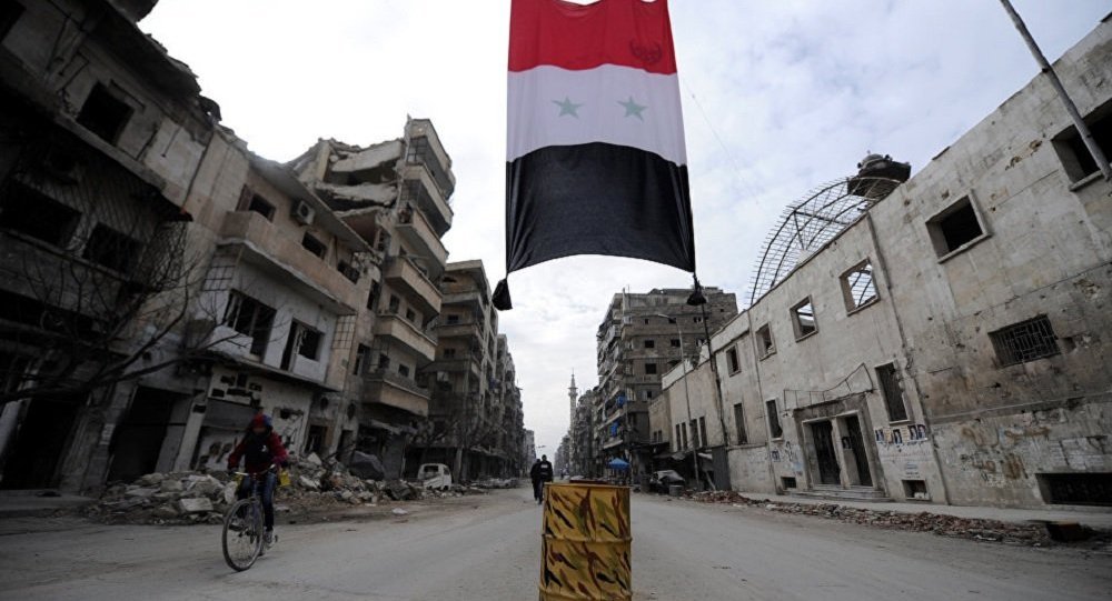 A Syrian national flag hangs in a damaged neighbourhood in Aleppo, Syria