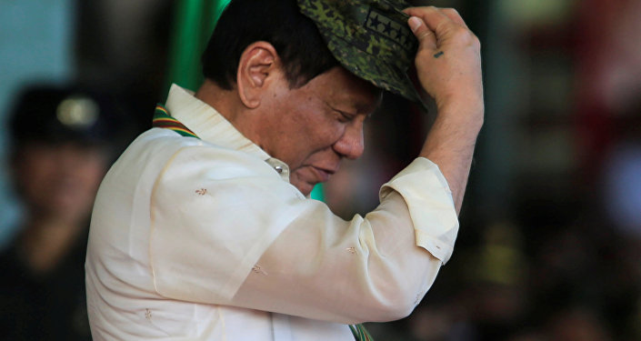 Philippine President Rodrigo Duterte tries on a military hat given to him during the 120th founding anniversary of the Philippine Army (PA) at Taguig city, metro Manila, Philippines April 4, 2017