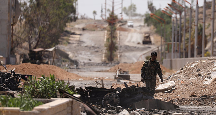 A Syrian Democratic Forces (SDF) fighter walks through a damaged street in the town of Tabqa, after SDF captured it from Islamic State militants this week, in Raqqa, Syria May 12, 2017