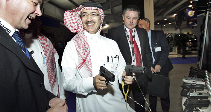 Mahmoud Al-Gahtani of Saudi Arabia, center, inspects guns during the opening of the Special Operations Forces Exhibition and Conference (SOFEX) held at the King Abdullah I airbase located near Amman in Jordan