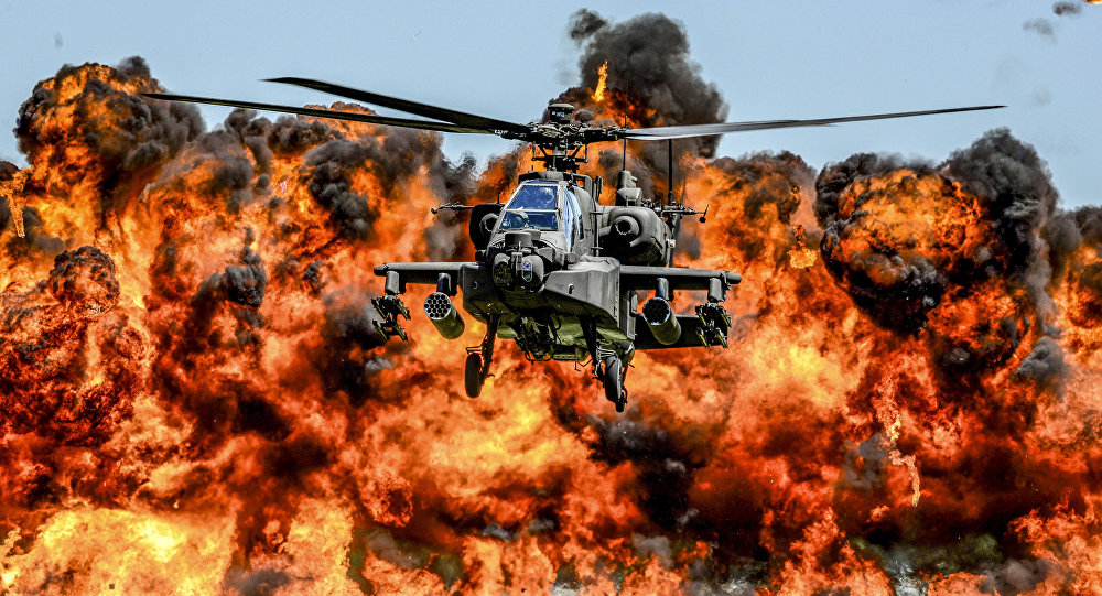 An AH-64D Apache attack helicopter flies in front of a wall of fire during the South Carolina National Guard Air and Ground Expo at McEntire Joint National Guard Base, South Carolina, U.S. on May 6, 2017