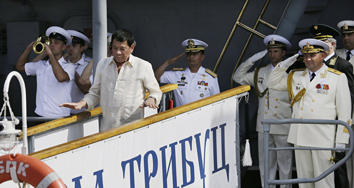 Russian Navy and a Philippine officer salute as Philippine President Rodrigo Duterte alights from the Russian anti-submarine Navy vessel Admiral Tributs in Manila, Philippines on Friday, Jan. 6, 2017