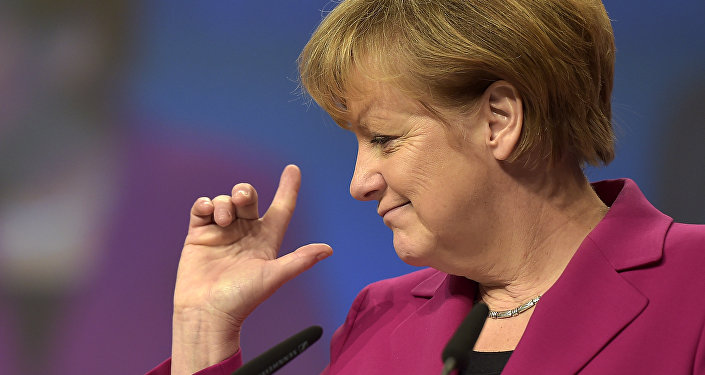 German Chancellor and chairwoman of the German Christian Democrats, CDU, Angela Merkel, points with her fingers during a visit to the convention venue prior to the 27. party convention in Cologne, Germany, Monday, Dec. 8, 2014.