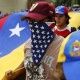 A Venezuelan opposition protester wearing a U.S. flag.