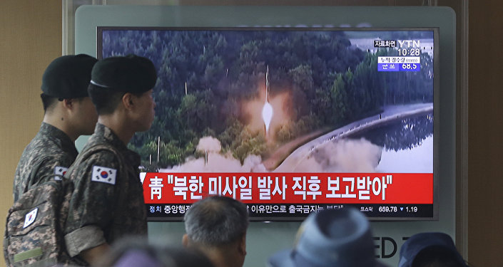 Army soldiers walk by a TV news program showing a file image of a missile being test-launched by North Korea at the Seoul Railway Station in Seoul, South Korea, Tuesday, July 4, 2017.