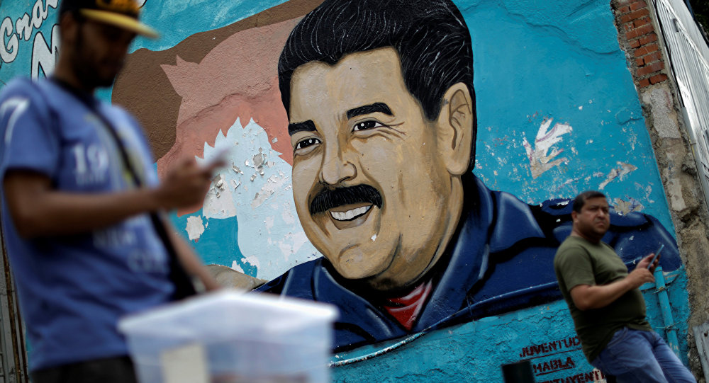A man walks past a portrait of Venezuela's President Nicolas Maduro in Caracas, Venezuela August 7, 2017.