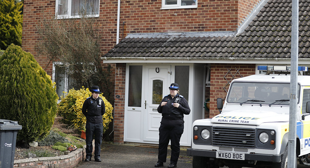Police officers stand outside the house of former Russian double agent Sergei Skripal who was found critically ill Sunday following exposure to an unknown substance in Salisbury, England, Tuesday, March 6, 2018