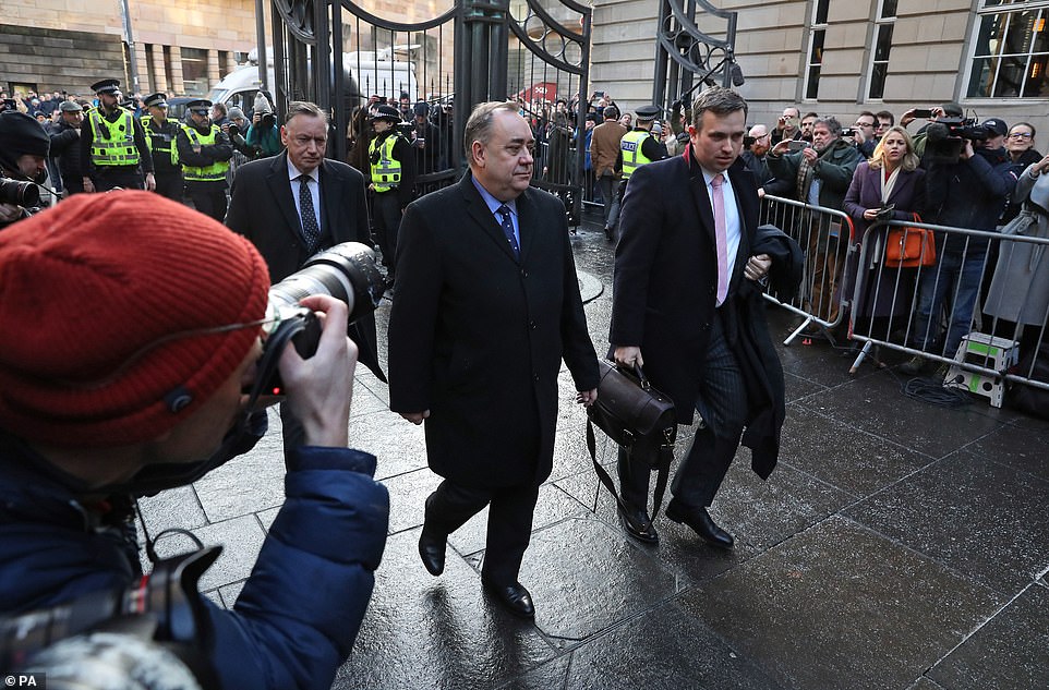 Photographers take pictures of the former Scottish first minister arriving at the court today