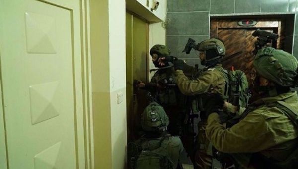 An undated photo by Palestinian media shows Israeli forces breaking into a Palestinian home.