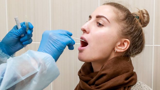 Woman having throat swab taken