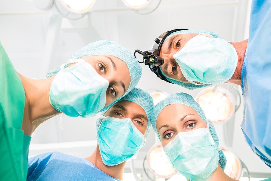 Hospital - surgery medical team of doctors in operation room or Op operating on patient in an emergency