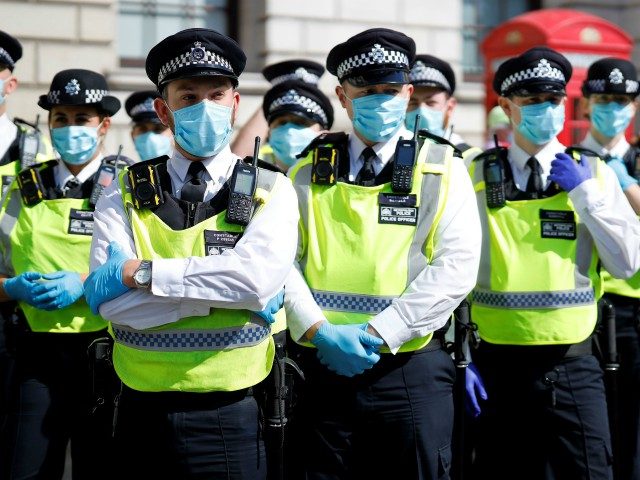 Police officers wearing face masks and gloves due to the COVID-19 pandemic, stand on duty as activists from the climate protest group Extinction Rebellion demonstrate in Parliament Square in London on September 2, 2020, on the second day of their new season of "mass rebellions". - Climate protest group Extinction …